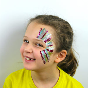 Final step, Applying fine gold glitter in stripes to complete the stripy glitter face paint.
