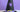 Close-up of a black witch hat decorated with a purple spider, purple band and bright yellow buckle.