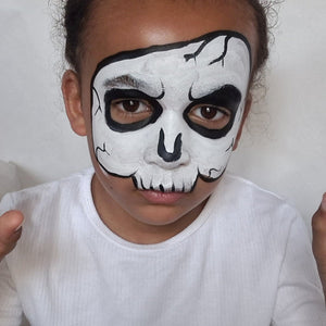 Final step, Outlining the skull with black and painting thin lines for cracks and teeth to complete skull face paint.