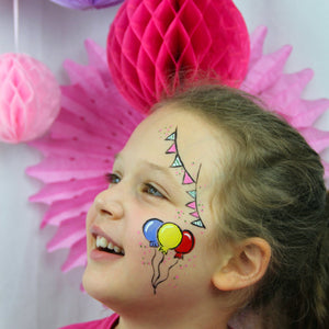 Final step, adding white and pink highlights to complete Birthday Balloons face paint.