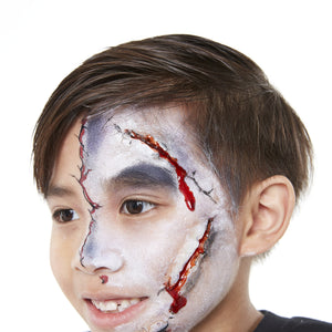 Final step, adding cracks and blood highlights using gel blood to complete Zombie face paint.