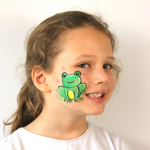 Final step, adding white highlights and pink flowers around the frog to complete the Spring Frog face paint.
