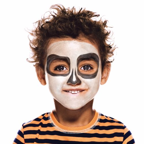 Boy with step 2 of Cheeky Skeleton Halloween face paint design